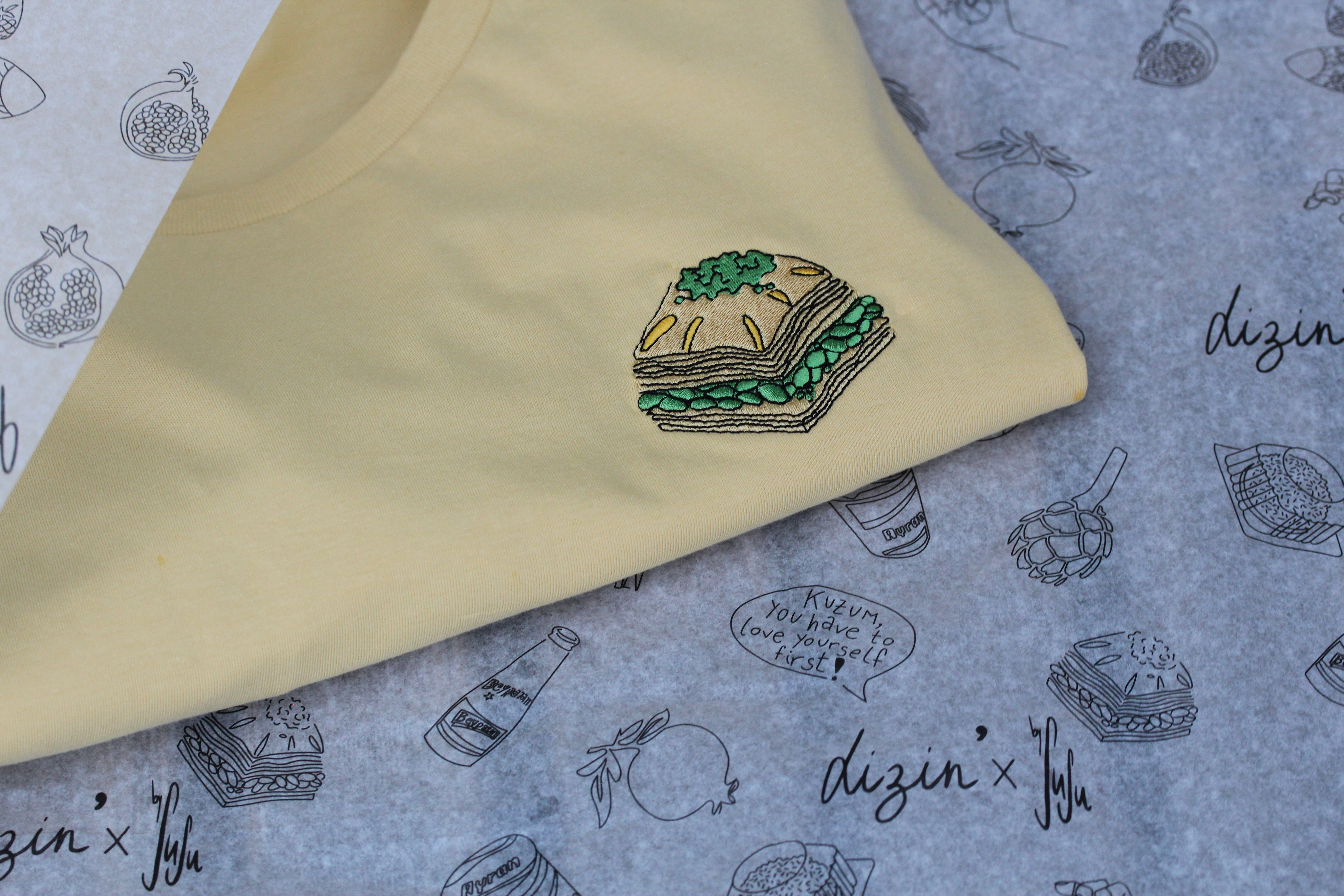Nachhaltiges Baklava T-Shirt aus Bio-Baumwolle in gelb. Auf der linken Brust ist ein Stück Baklava gestickt.